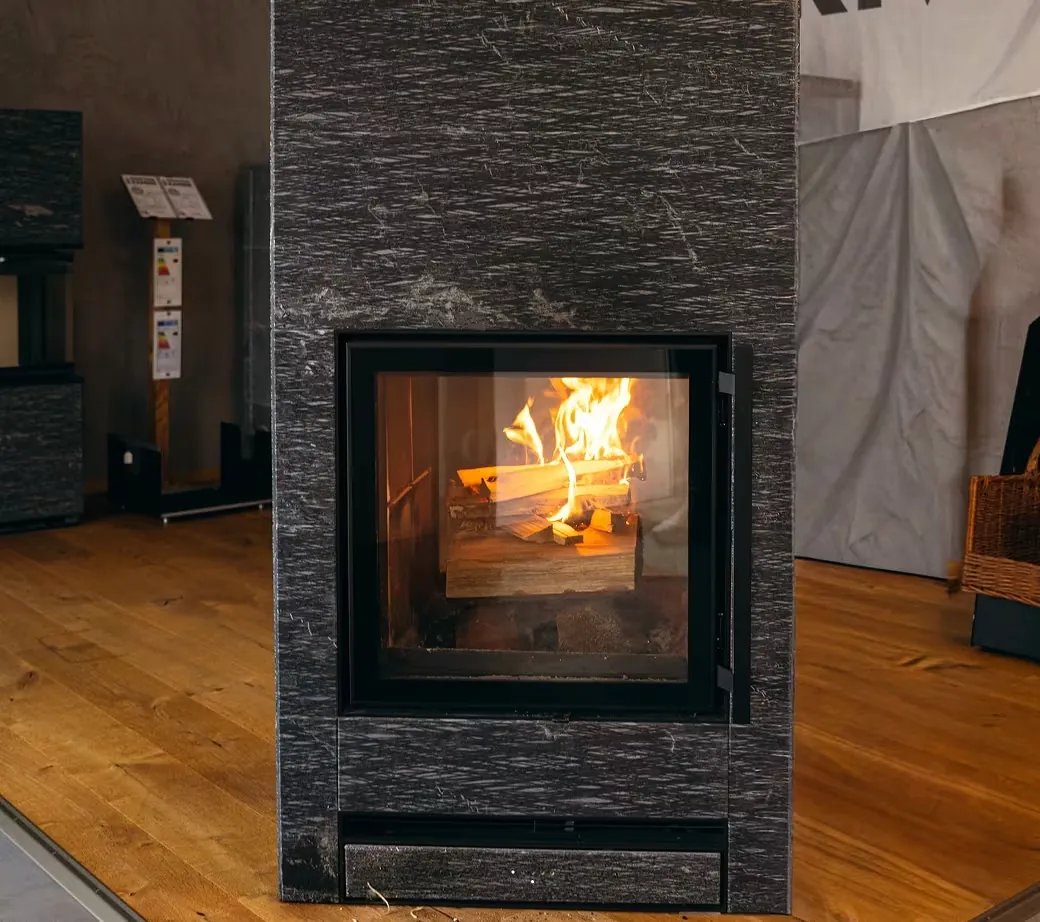 Kamin mit Holzfeuer in moderner Steinwand
